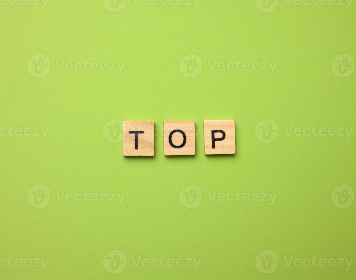 inscription top from wooden cubes on a green background photo