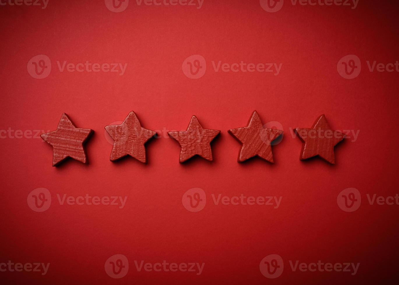 five red wooden stars on a red background photo