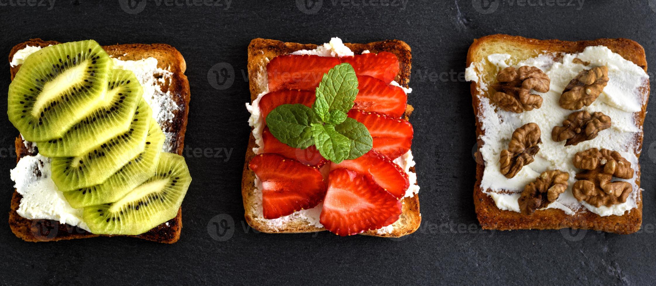 tres tostadas con requesón suave, fresas, kiwi y nueces foto