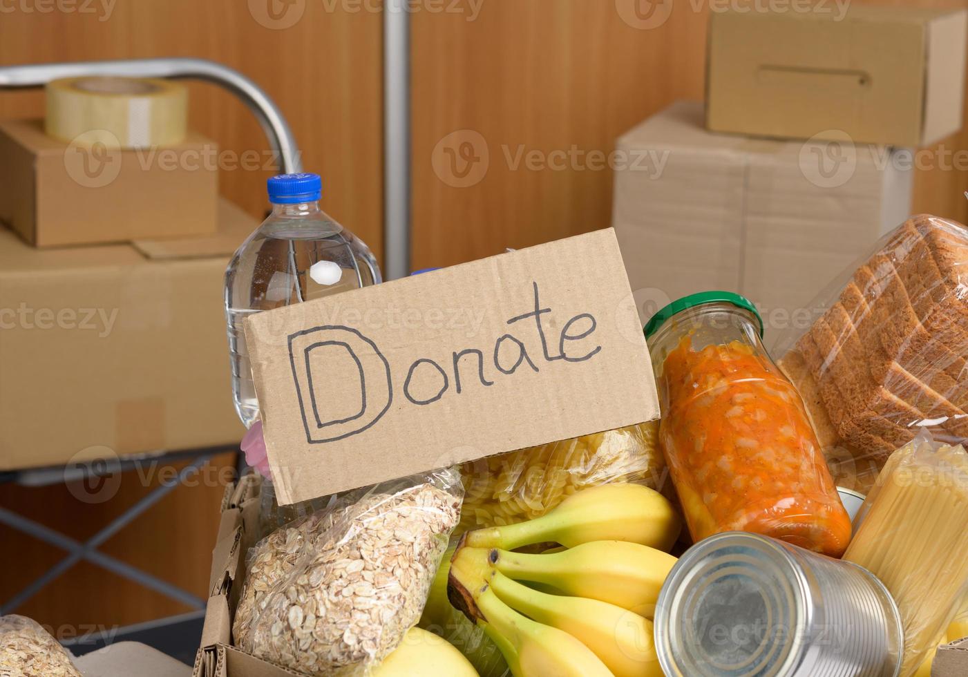 cardboard box with various products, fruits, pasta, sunflower oil in a plastic bottle and preservation photo
