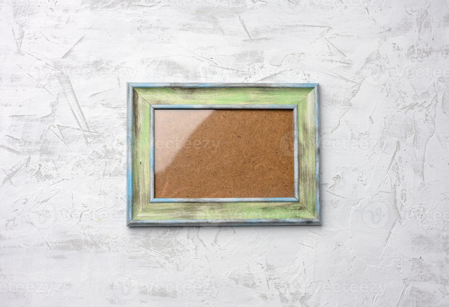 wooden frame hanging on white cement wall photo