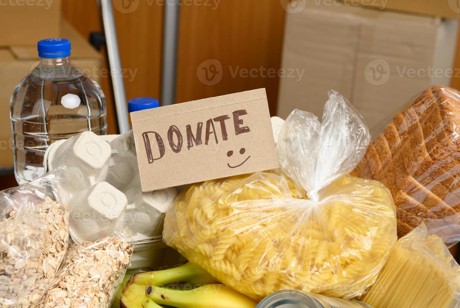 cardboard box with various products, fruits, pasta, sunflower oil in a plastic bottle photo