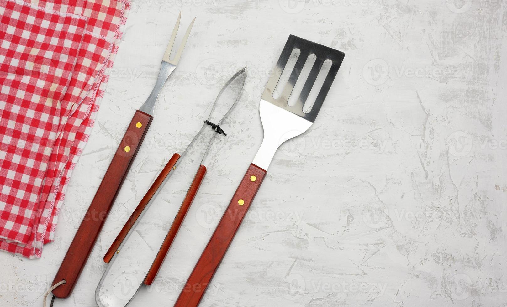 metal kitchen items with wooden handles for barbecue on white background photo