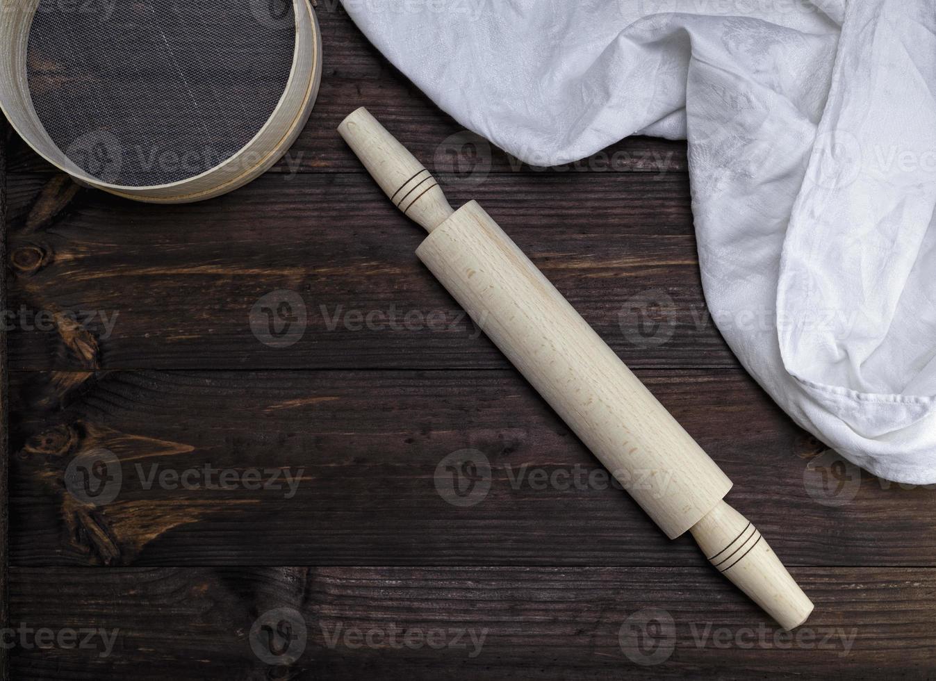wooden rolling pin and a wooden round sieve photo