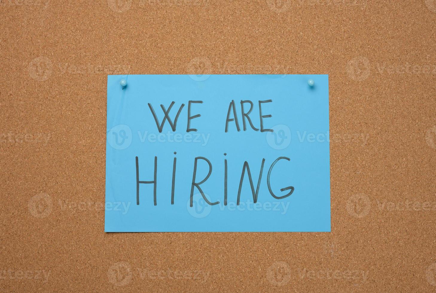 blue sheet of paper with an inscription on a brown cork board. Recruitment concept, vacancy photo