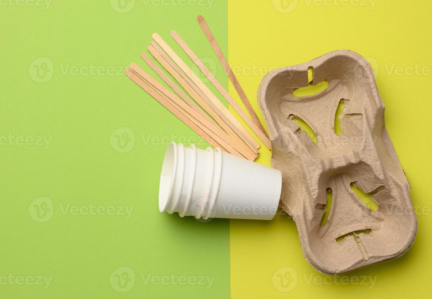 white paper disposable cups and brown tray, green background photo