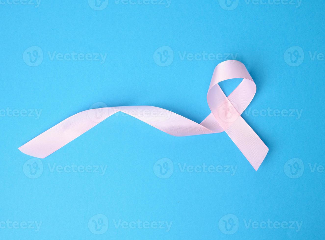 pink silk ribbon in the shape of a loop on a blue background photo