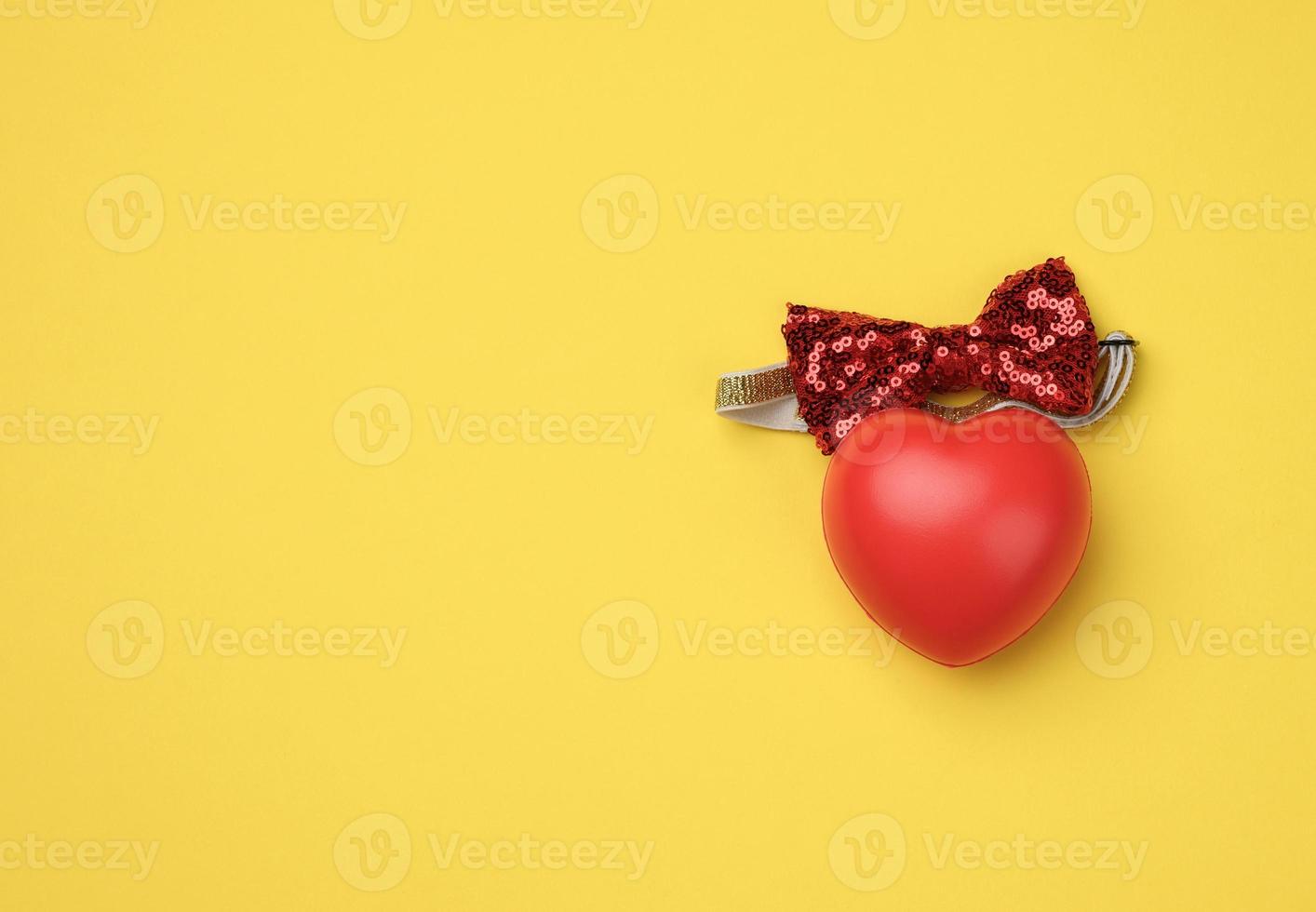 red rubber heart on a yellow background photo