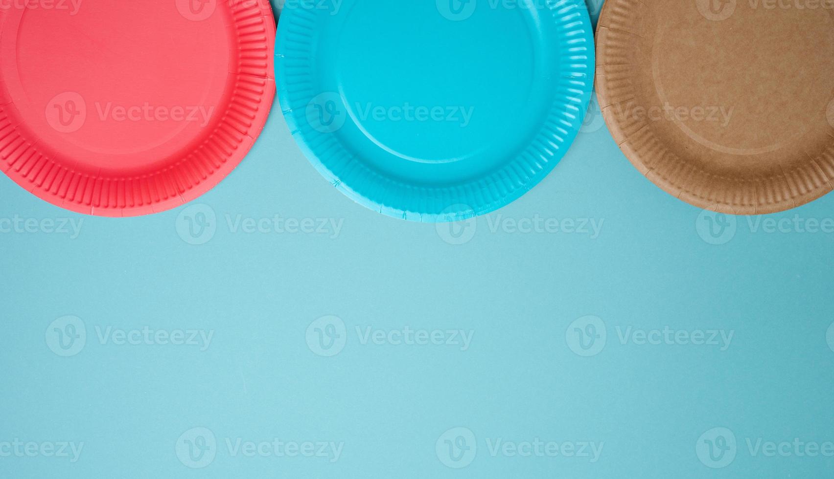 Empty paper disposable plates on a blue background, top view. photo