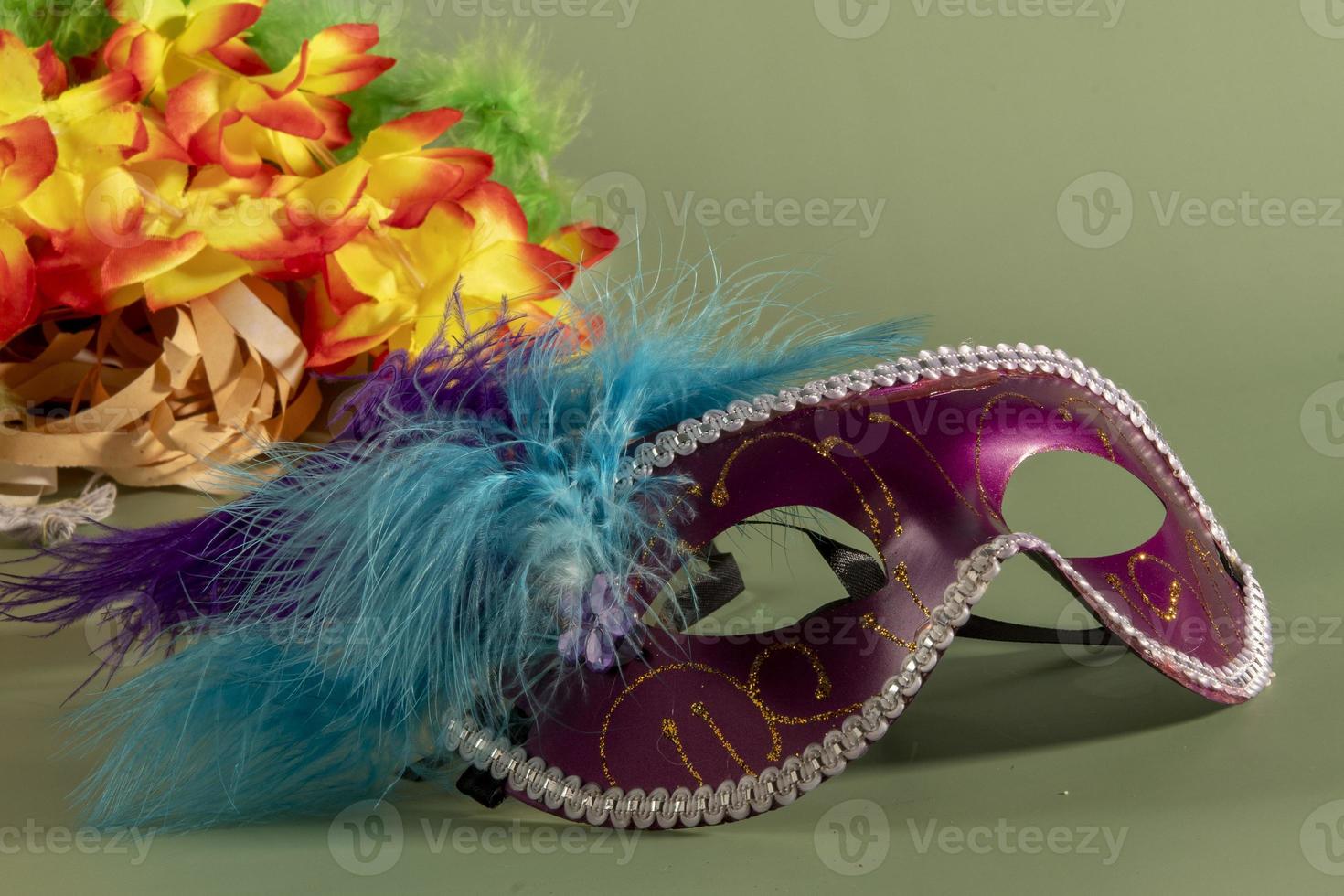 Venetian carnival mask with feathers, and typical elements in the background photo