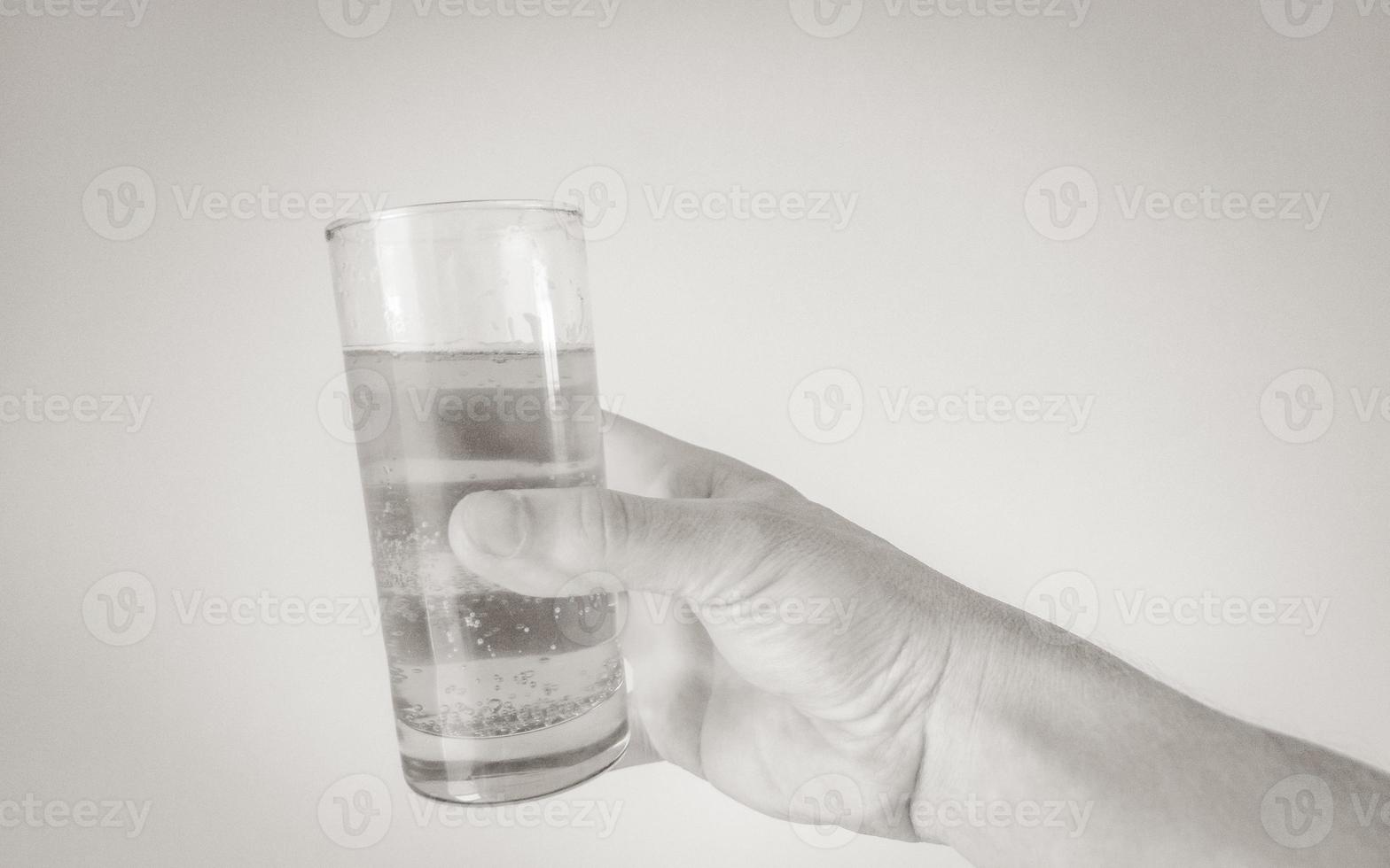 mano con vaso lleno de cerveza sobre fondo blanco. salud foto