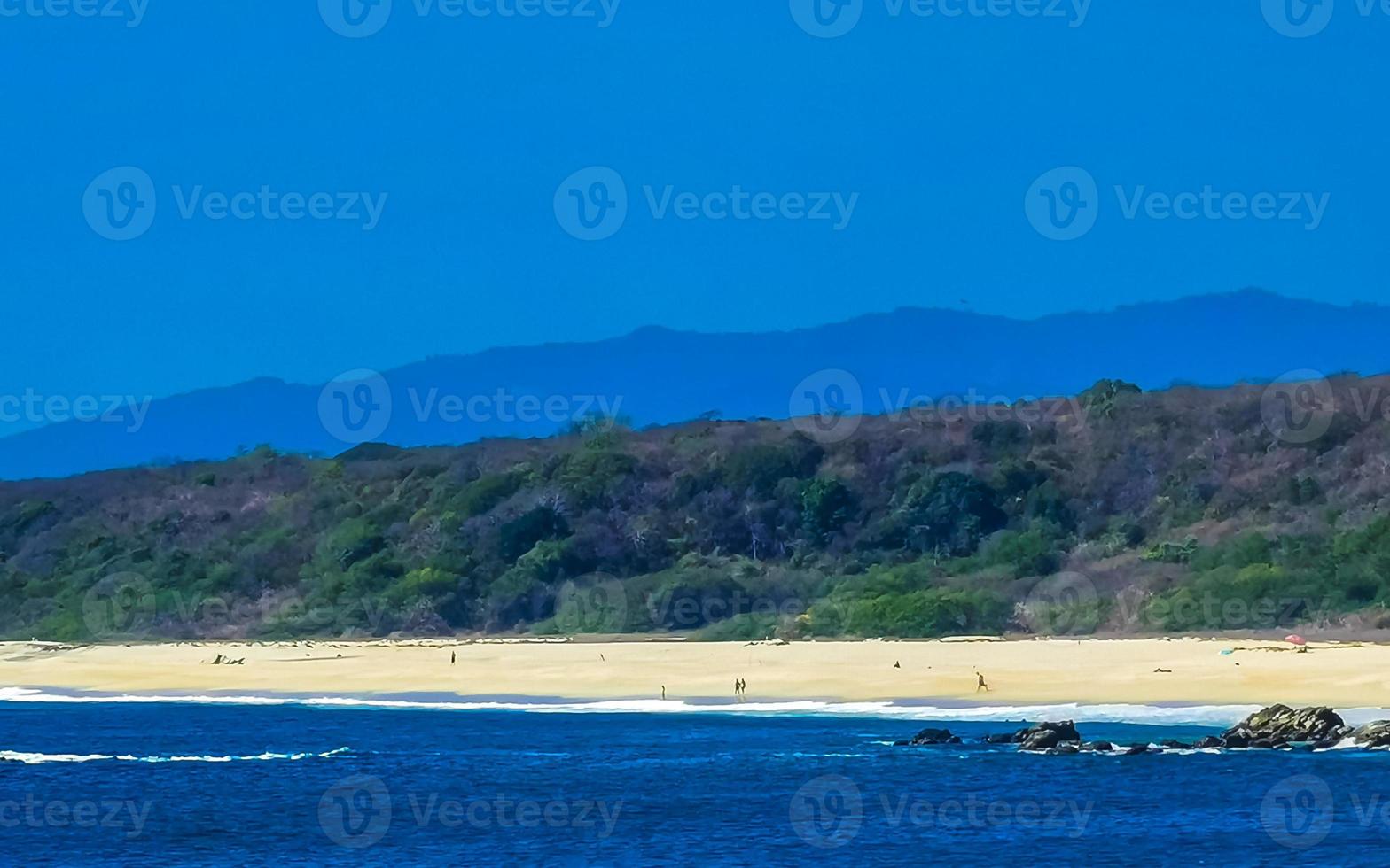 Beautiful rocks cliffs view waves at beach Puerto Escondido Mexico. photo