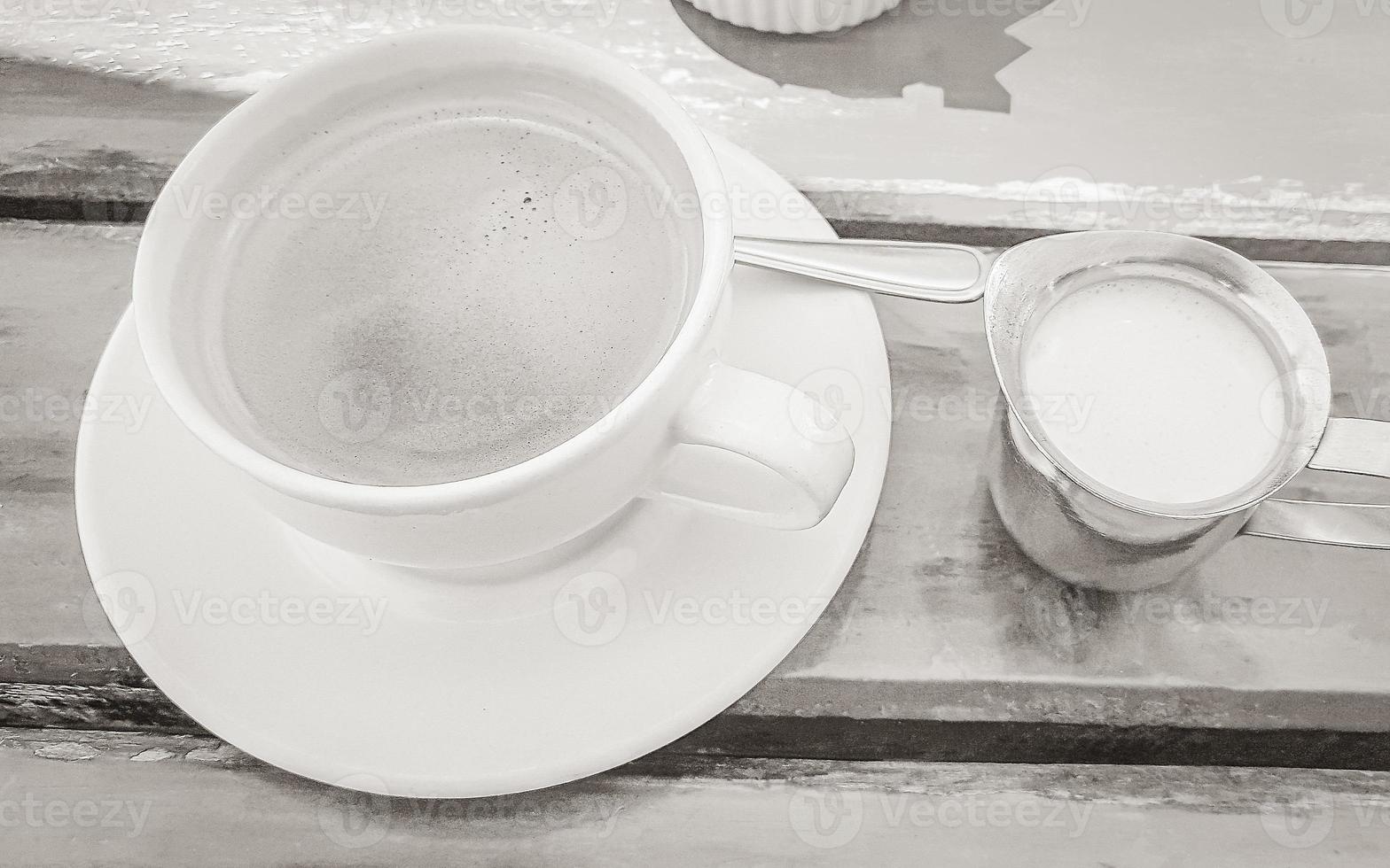 Cup of coffee on old wooden table restaurant at coast. photo