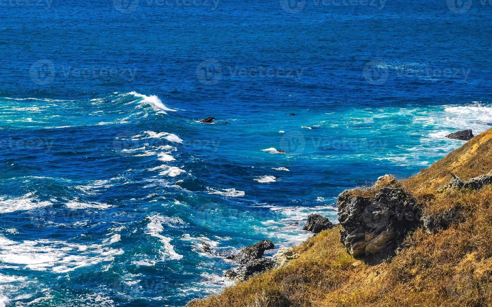 Beautiful rocks cliffs view waves at beach Puerto Escondido Mexico. photo
