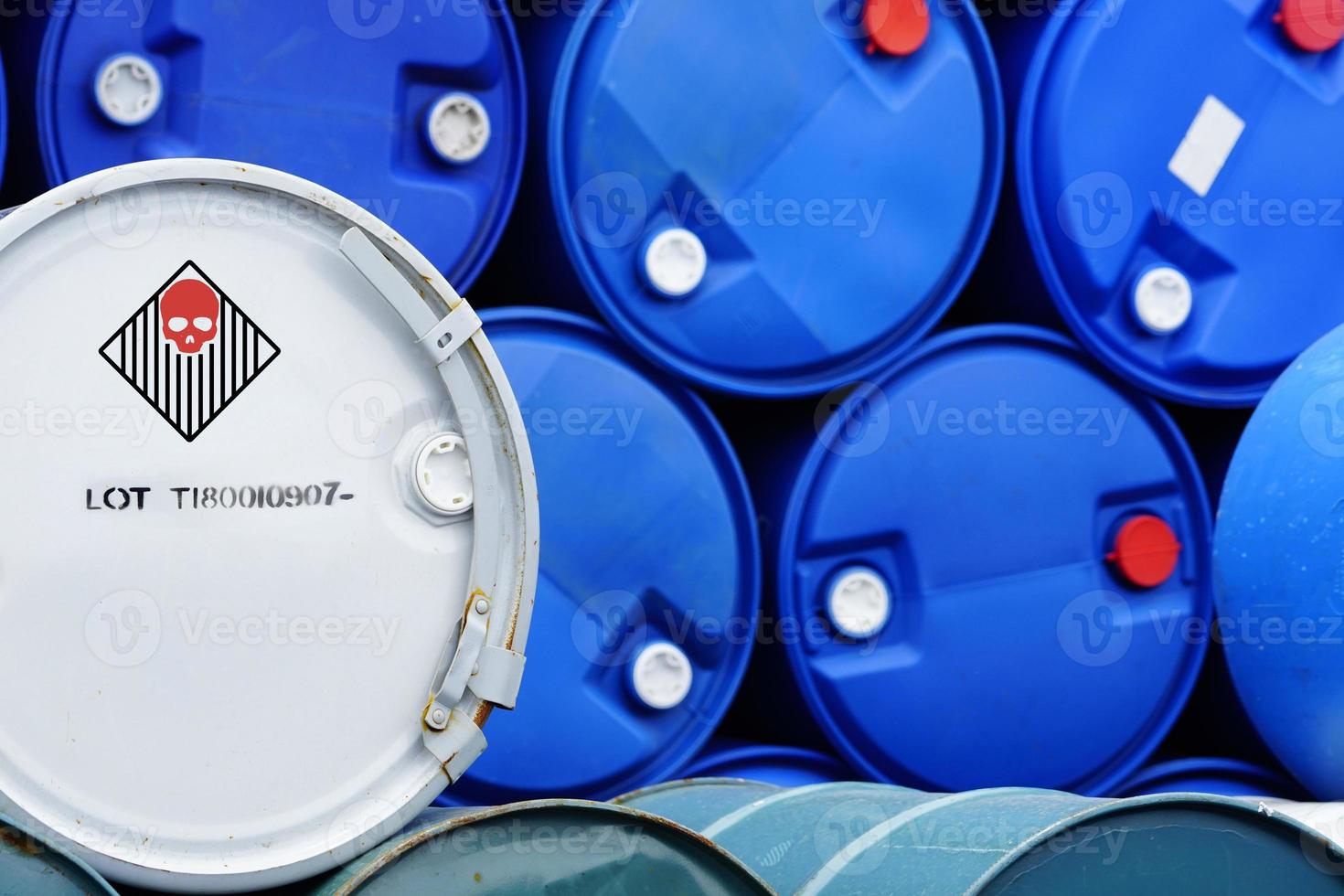 Old chemical barrels. Blue and green oil drum. Steel and plastic oil tank. Toxic waste warehouse. Hazard chemical barrel with warning label. Industrial waste in drum. Hazard waste storage in factory. photo