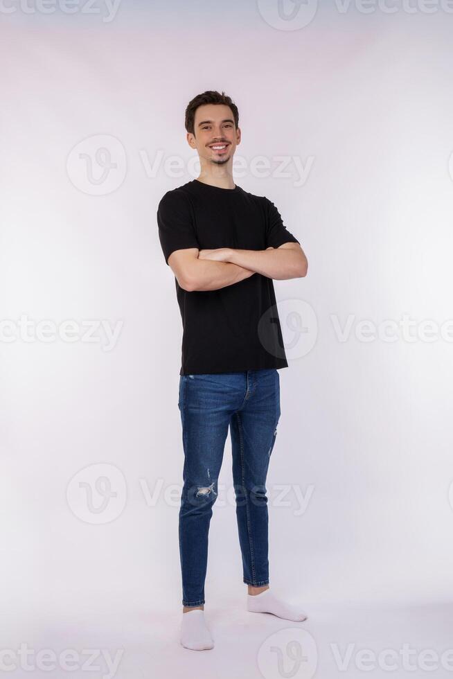 Portrait of young handsome man wearing black t-shirt, standing with crossed arms with isolated on studio white background photo