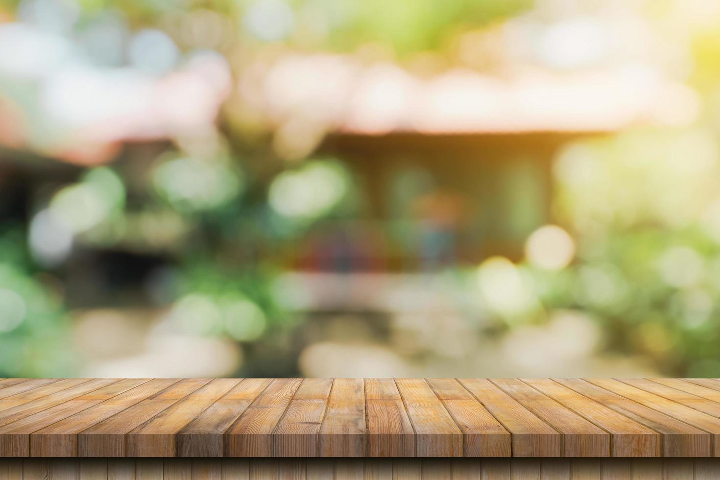 Empty wood table and defocused bokeh and blur background of garden trees with sunlight. product display template. photo