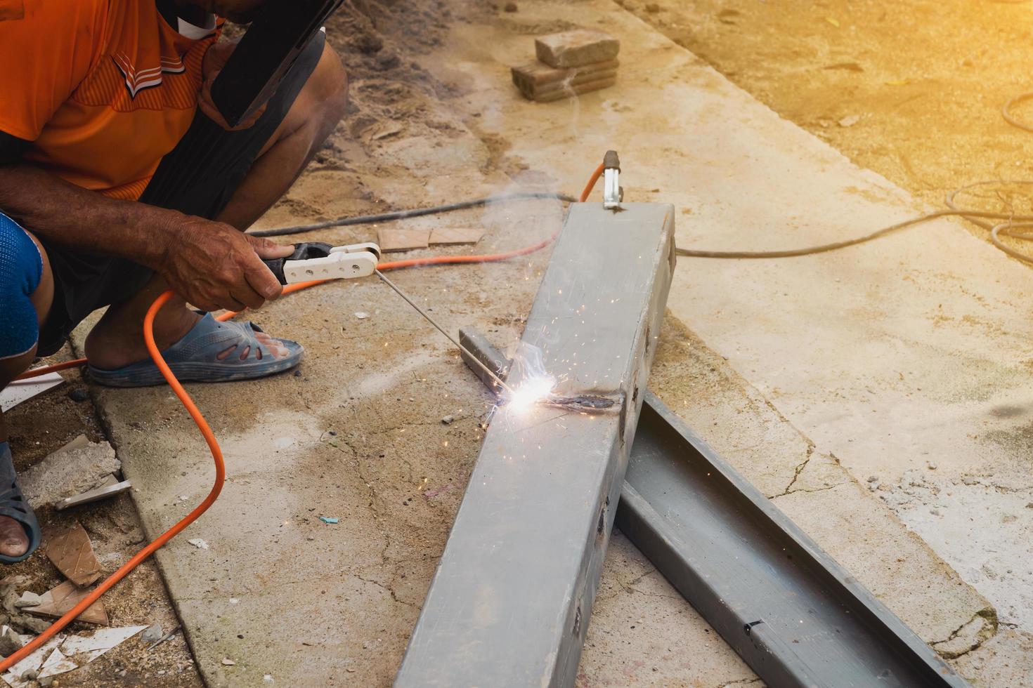 Man welder doing a metal staircase structure in a residential building using a welding machine. photo