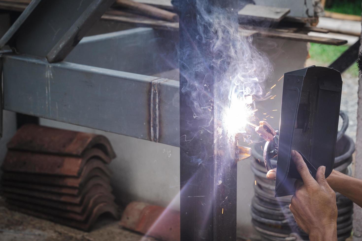 Man welder doing a metal staircase structure in a residential building using a welding machine. photo