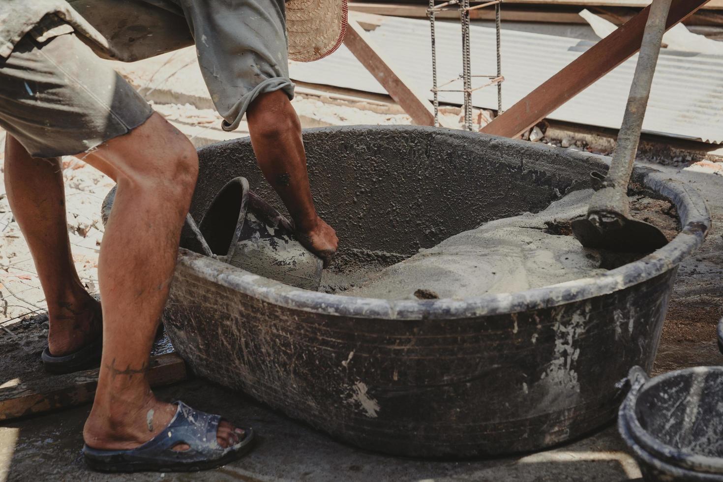 worker mixing cement mortar plaster for construction photo