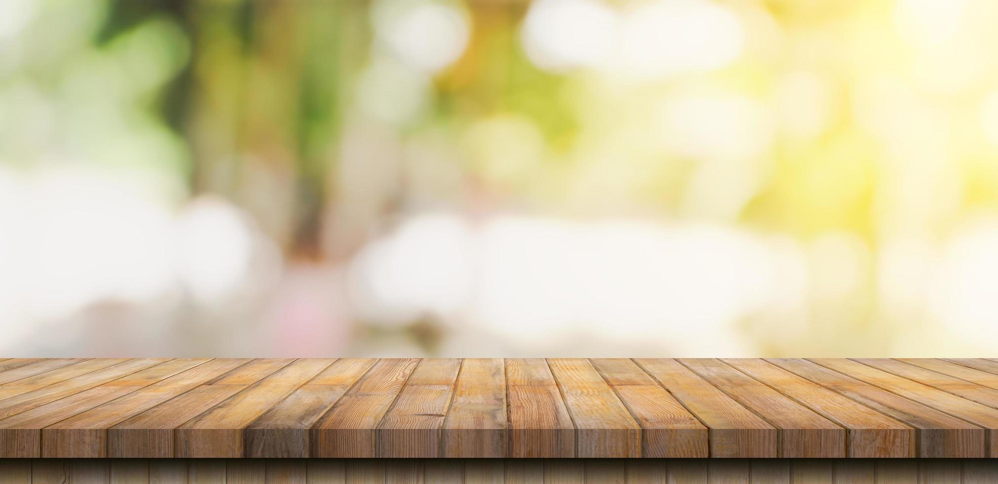 mesa de madera vacía y mesa de luz borrosa en cafetería y café con fondo de bokeh. plantilla de exhibición de productos. foto