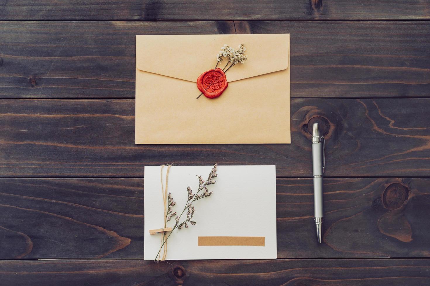 Above of greeting card and pen on wood background photo