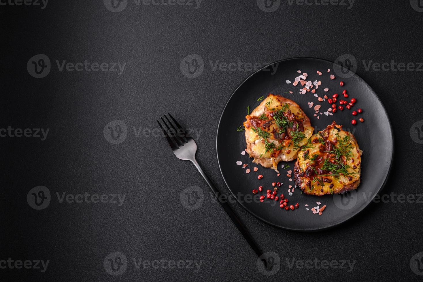 Meat baked in the oven with pineapple, tomatoes, cheese, spices and herbs photo
