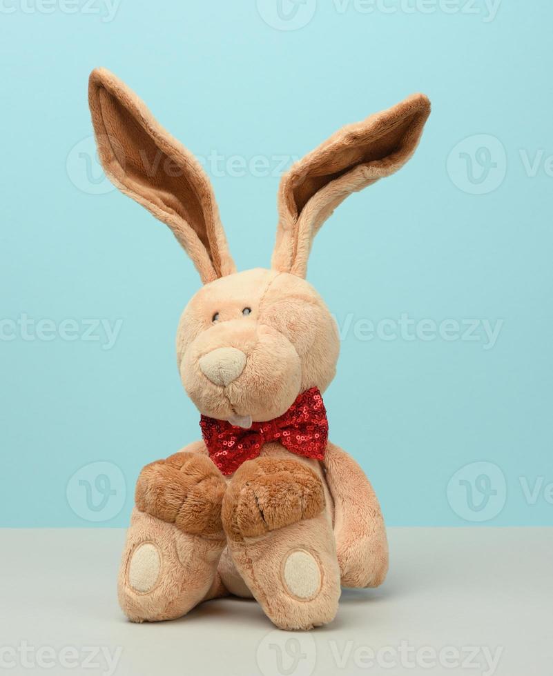 cute plush hare with long ears, a red butterfly tied around the neck photo