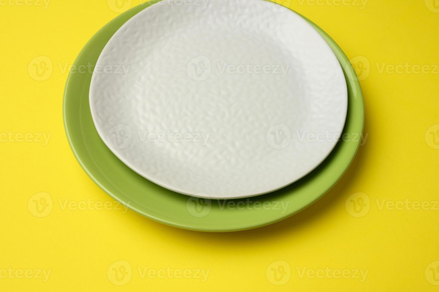 empty round white plate for main courses on a yellow background photo