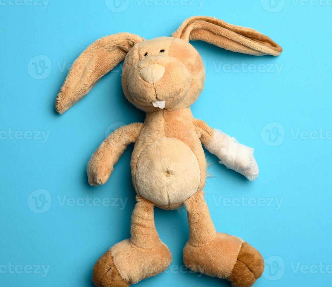 soft plush rabbit with a bandaged paw with a white medical bandage photo