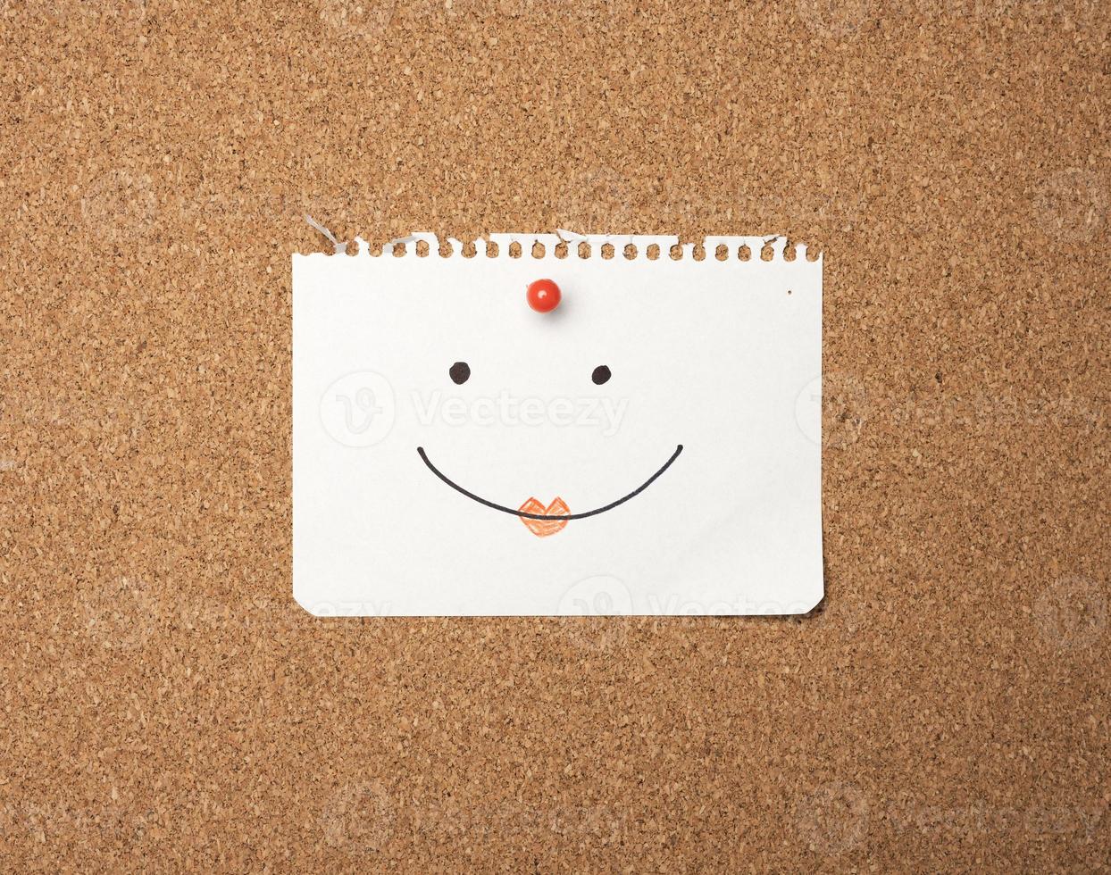 paper sheet with joyful emotion attached by button on brown board photo