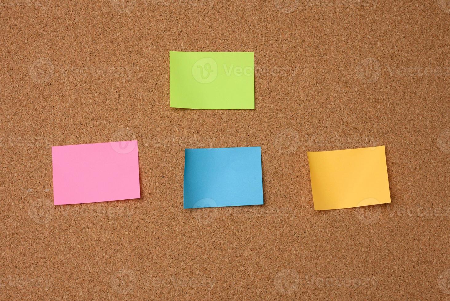multicolored square sticks are glued to the brown cork texture photo