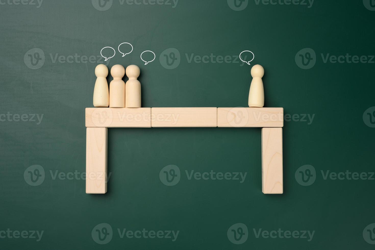 groups of wooden figures of men stand opposite each other. Conflict of interest concept, dialogue building, compromise solutions photo