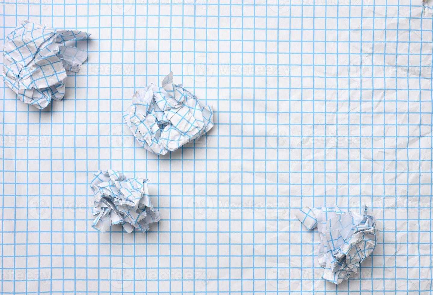 blank crumpled white sheet of paper in a cage and crumpled balls, top view photo