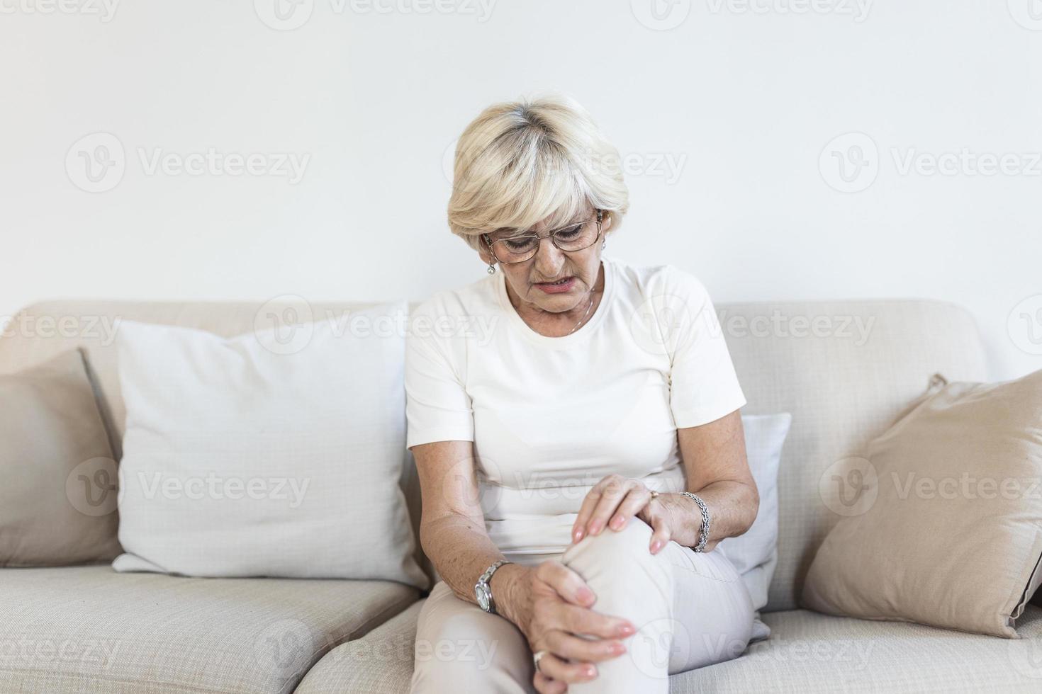 anciana sosteniendo la rodilla con dolor. vejez, problema de salud y concepto de personas - mujer mayor que sufre de dolor en la pierna en casa. anciana que sufre de dolor en la rodilla en casa foto