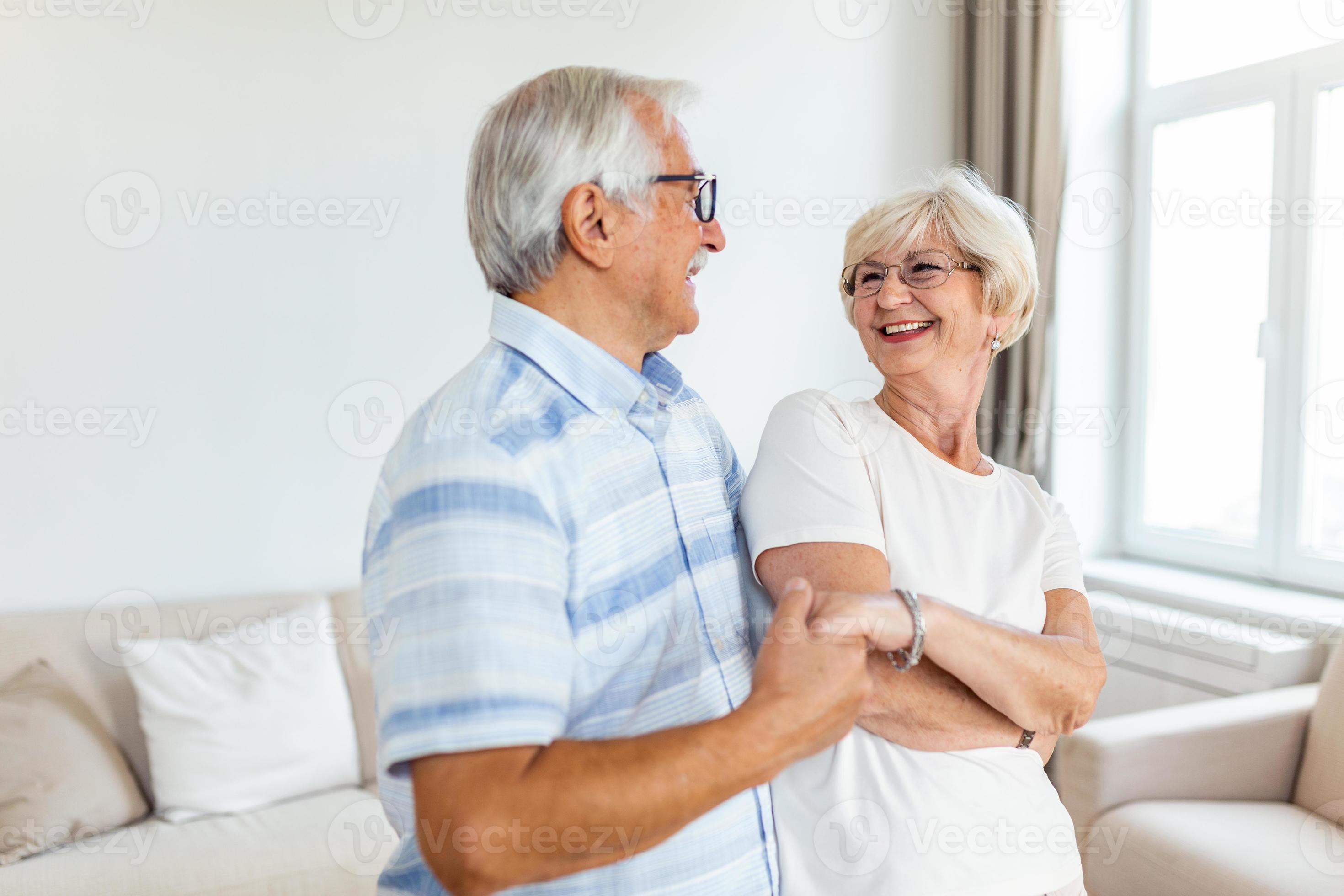 Senior couple relaxing at home, dancing. Elderly couple are enjoying a  dance in the living room of their home. 19607764 Stock Photo at Vecteezy