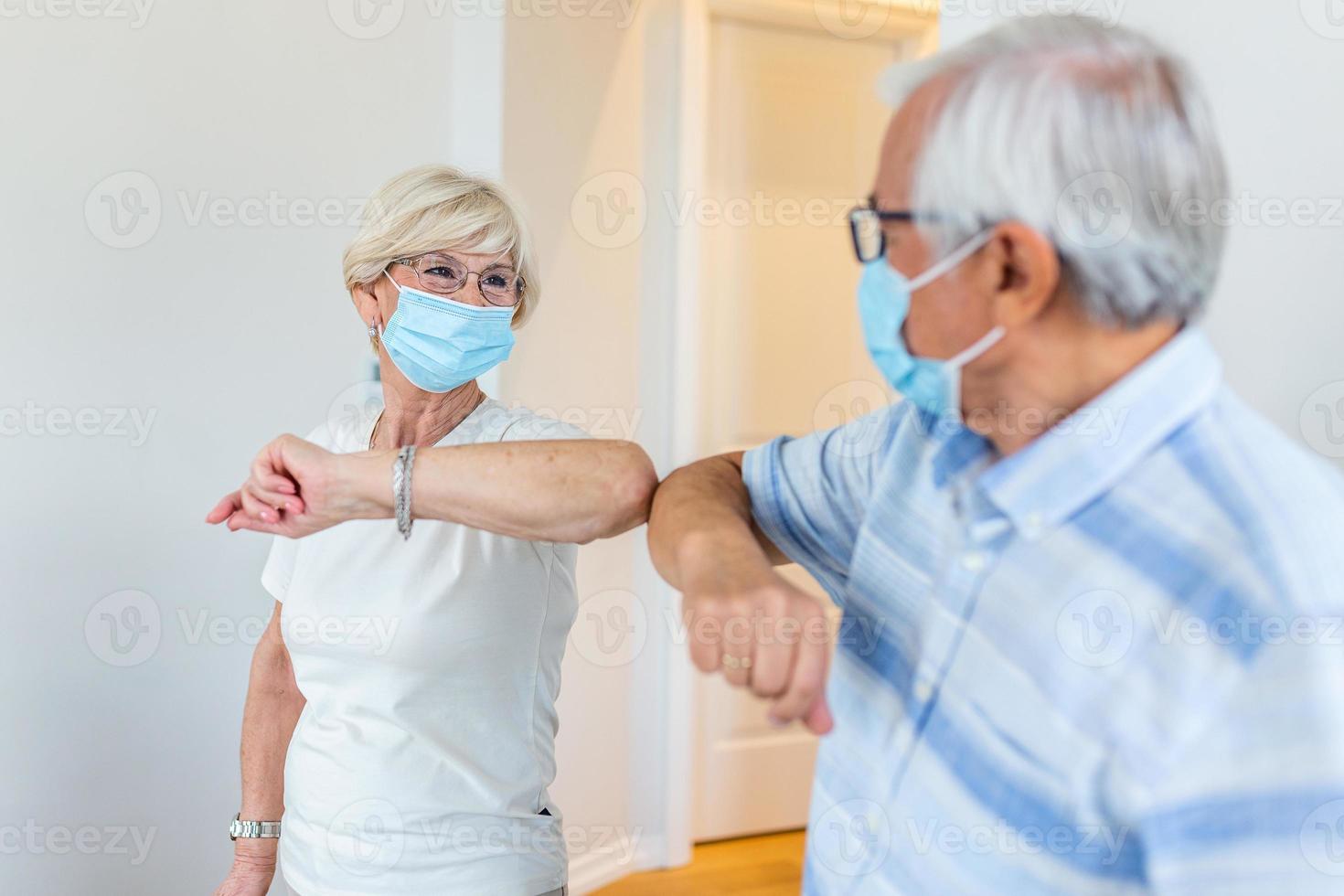 amigos mayores sonrientes y amistosos que mantienen la distancia social, saludándose unos a otros golpeándose los codos en lugar de abrazos o apretones de manos, evitando la propagación de la infección por el coronavirus covid 19. foto