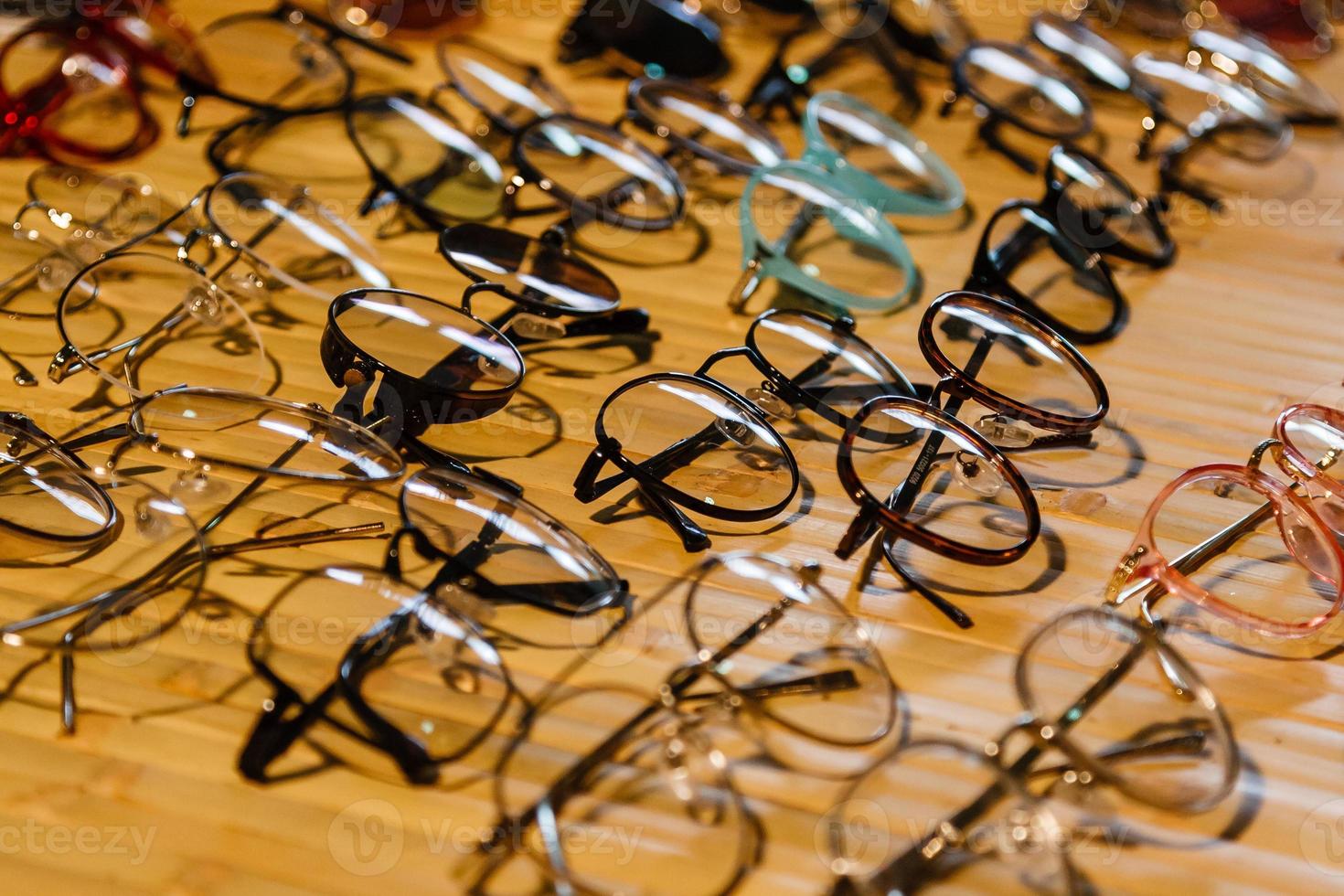 large selection of sunglasses and glasses on a stand photo