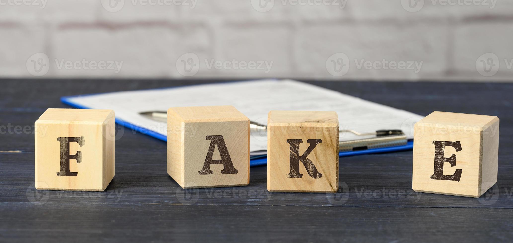 wooden cubes with the inscription fake on a blue background. The concept of information hygiene, propaganda photo