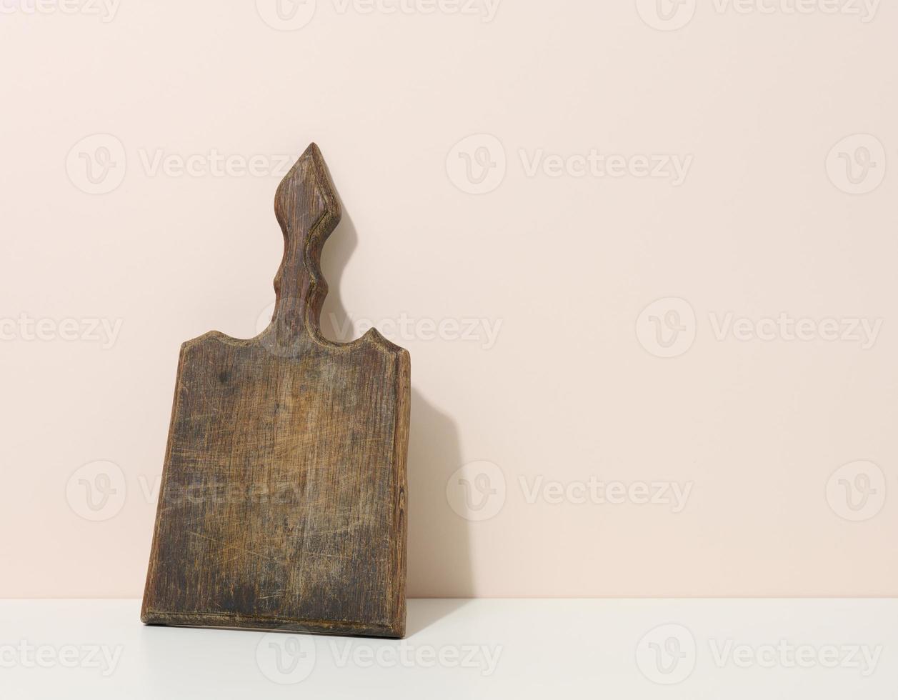 empty brown wooden kitchen board on a white table, utensils photo