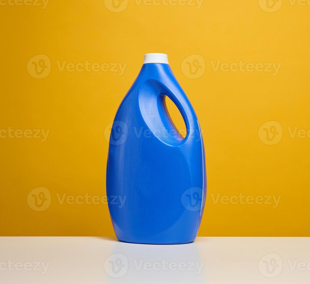 plastic blue bottle with liquid detergent stand on a white table photo