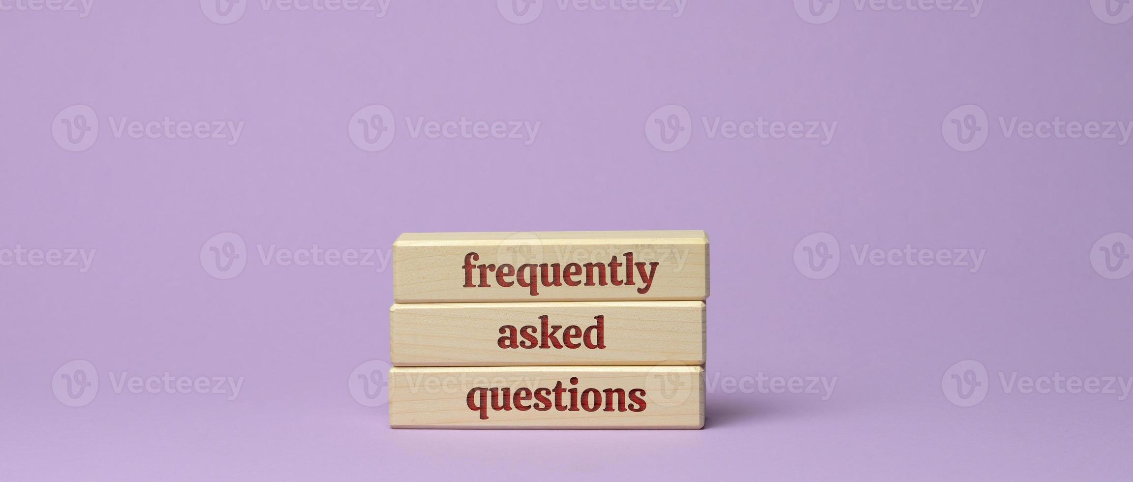 inscription frequently asked questions on wooden blocks on a purple background photo