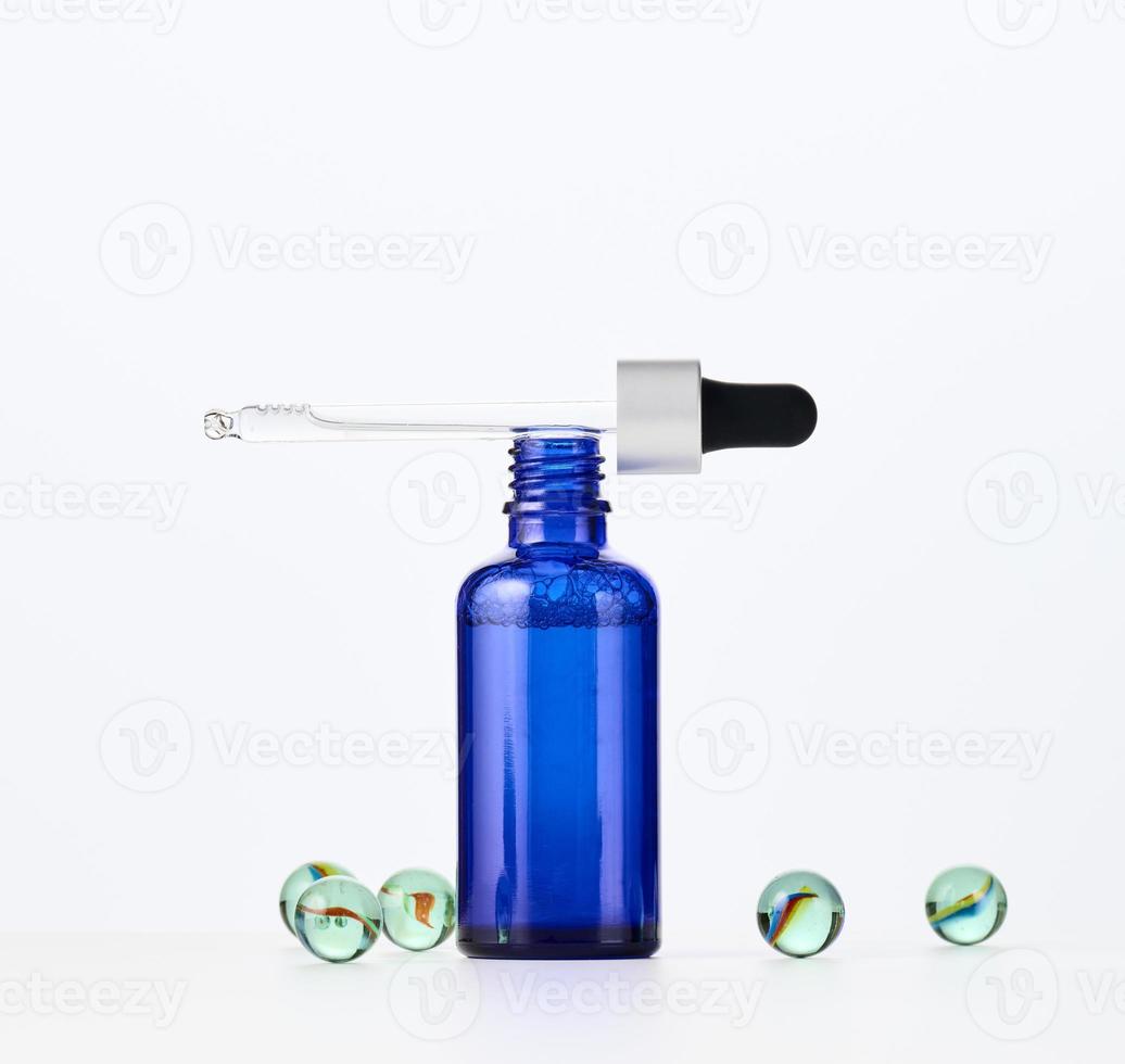 glass bottle with a pipette on a white background. Template for cosmetic liquid products, advertising and promotion photo