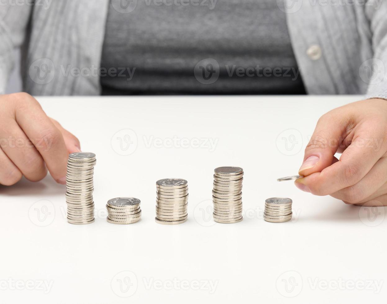 woman's hand puts money on a pile of money. Money saving concept. photo