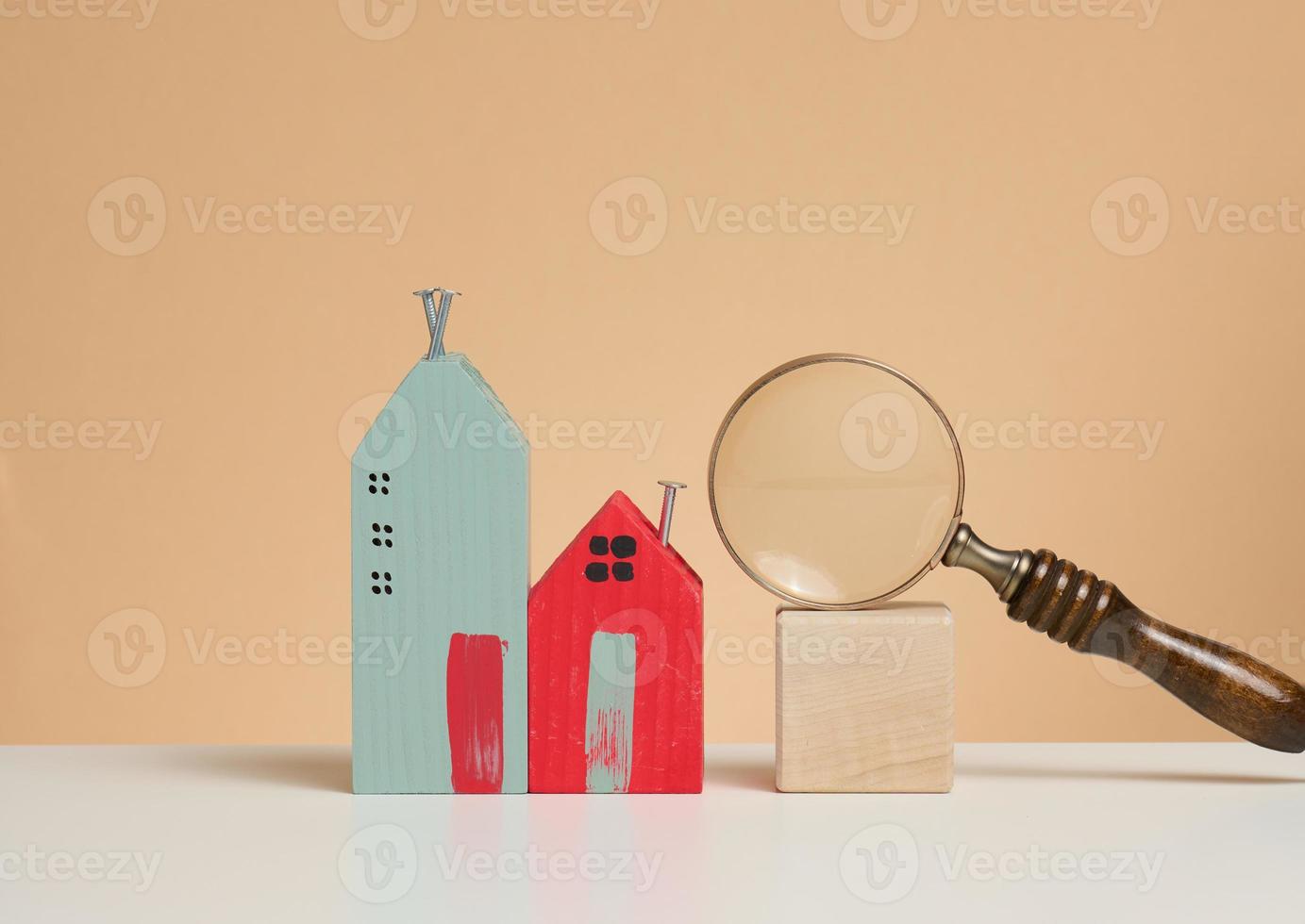 magnifier and wooden house on a brown background. Real estate rental, purchase and sale concept. Realtor services, building repair and maintenance photo