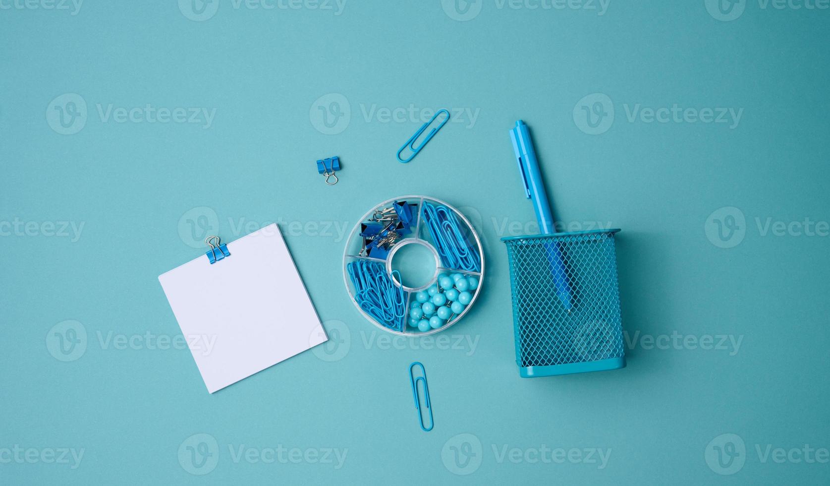 stack of white square sheets of paper for notes, stationery on blue background, top view photo
