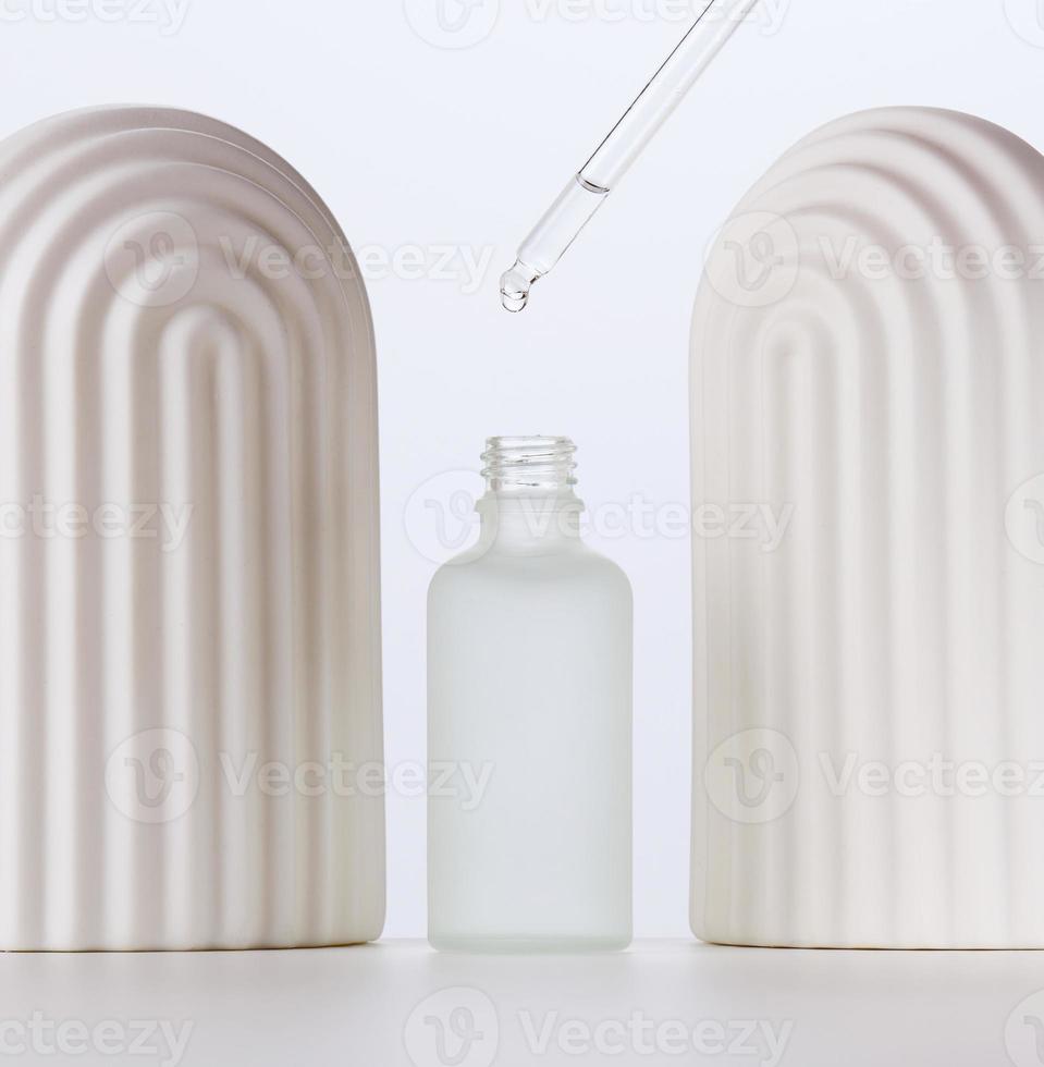 white glass bottle with pipette for cosmetics, oils and serum. Advertising and product promotion photo