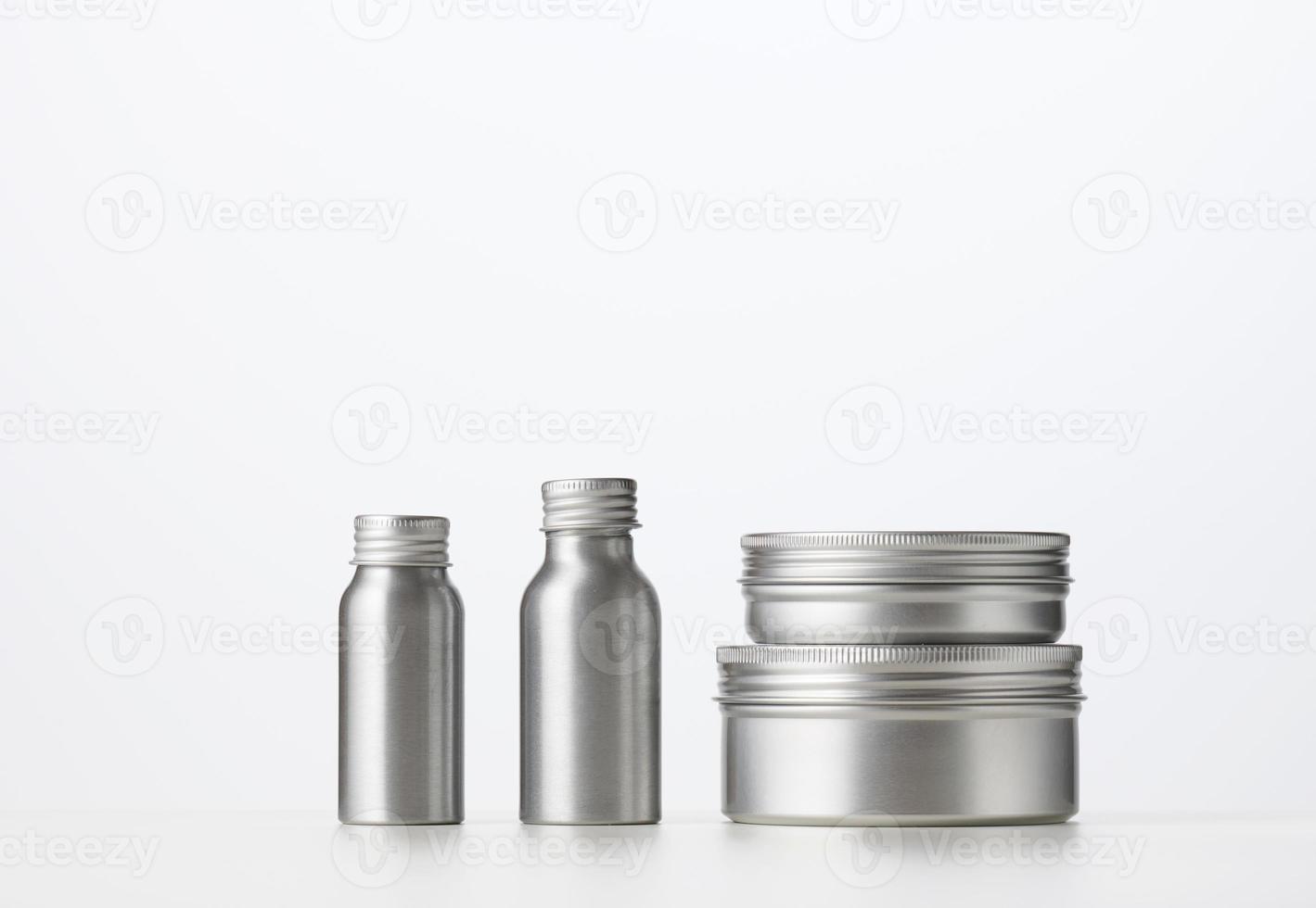 empty silver metal bottle for cosmetics on white table. Packaging for cream, gel, serum, photo