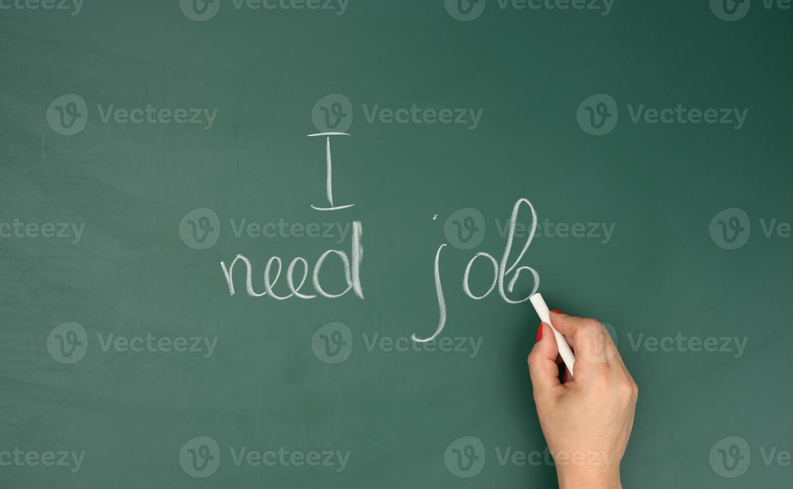 female hand wrote in white chalk I need work on a green chalk board. High unemployment concept photo