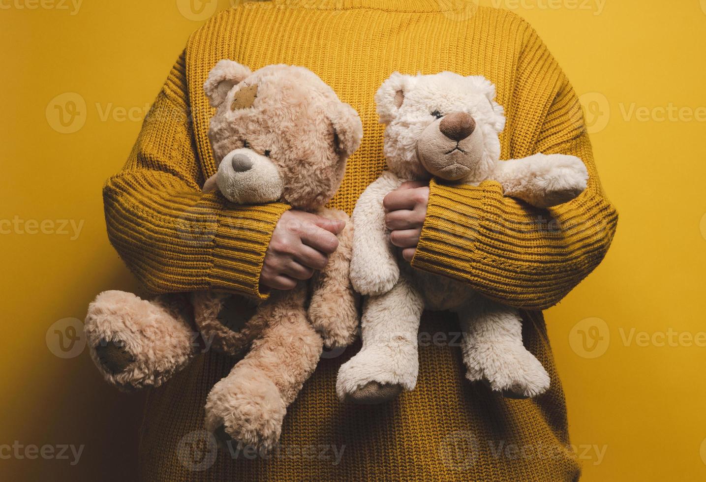 mujer en naranja de punto suéter abrazos linda marrón osito de peluche oso. el concepto de soledad y tristeza, depresión foto